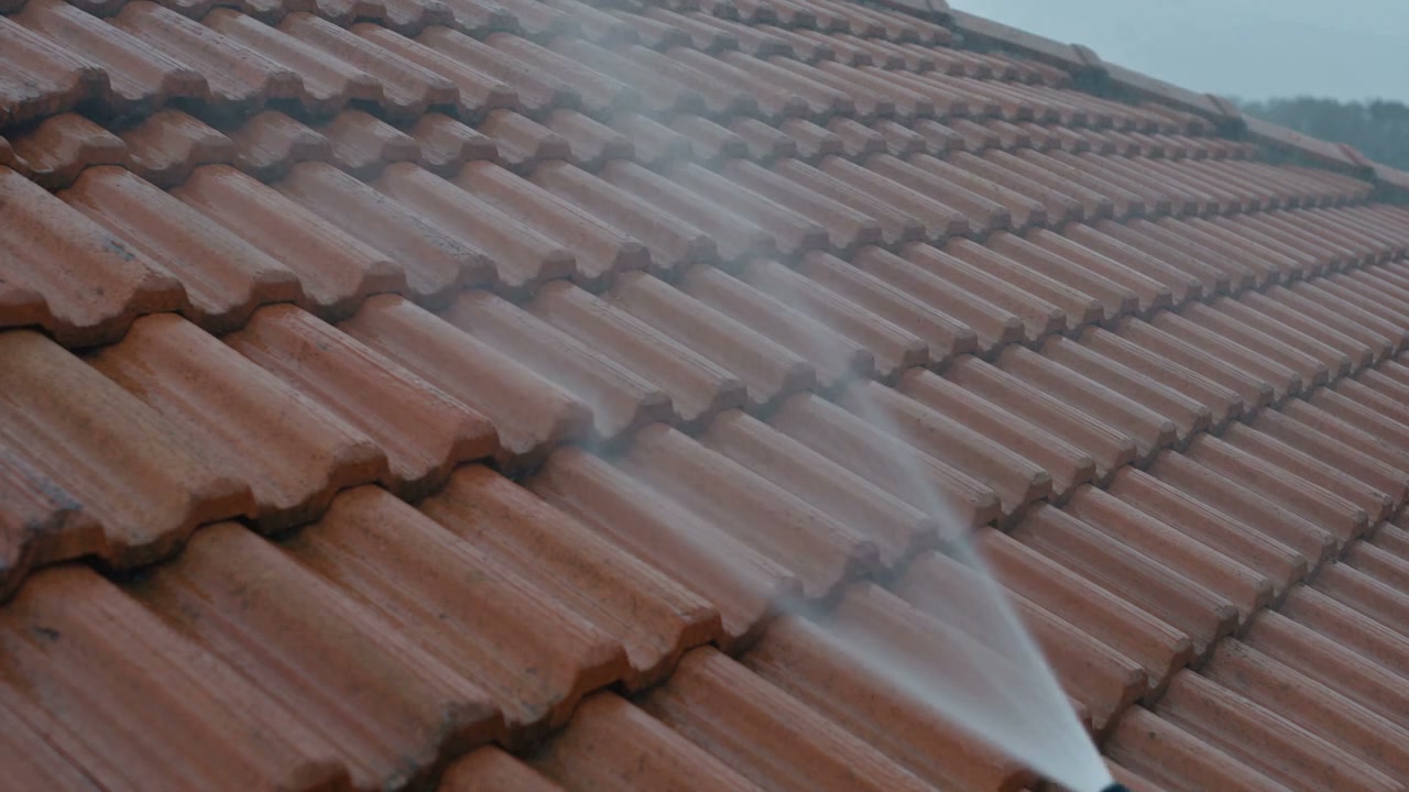 A hose test spraying water across a repaired tiled roof, from the film